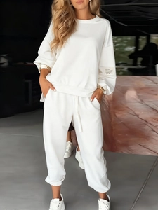 Detail of white knitted long-sleeve sweatshirt and casual pocket jogger pants set