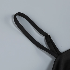 Macro view of adjustable black shoulder strap with silver metal buckle on a dress