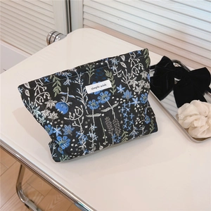 Macro detail view of the blue and green jacquard floral pattern on canvas makeup bag