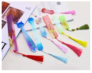 Detailed view of DIY resin bookmarks with cat paw shapes, glitter, and colorful tassels