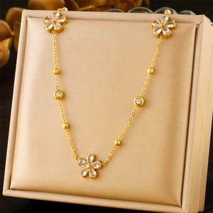 Close-up of golden floral necklace with white cubic zirconia on silk display