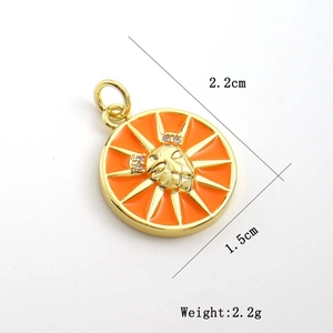 Detail view of orange sun face pendant with zircon inlay and gold dimensions 2.2x1.5cm