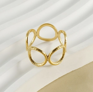 Macro detail of golden multi-loop geometric ring with textured hammer finish surface