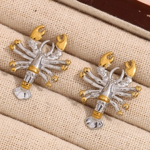 Macro shot of lobster shaped earrings in silver and gold duo-tone on a textured box