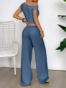 Rear view of blue textured two-piece set featuring one-shoulder top and wide-leg trousers