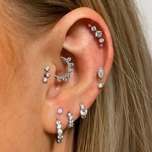 Close-up of S925 silver earrings with zircon stones worn as a stylish stack ensemble