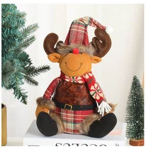 Graziosa renna di peluche a quadri su libri bianchi con mini alberi di Natale decor