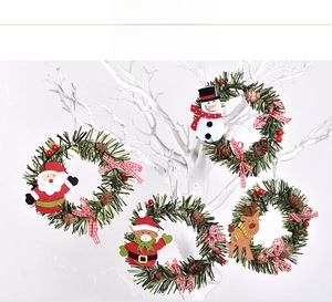 Detailed view of four Christmas wreath ornaments with Santa, snowman, elk and bear dolls