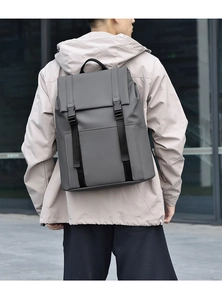 Minimalist grey business backpack with waterproof matte finish shown on a model