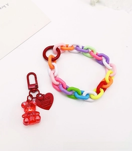 Close-up of colorful plastic chain wrist strap with a red bear pendant and metal clasp