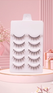 Set of 5 pairs of natural black false eyelashes on a white tray with pink floral background