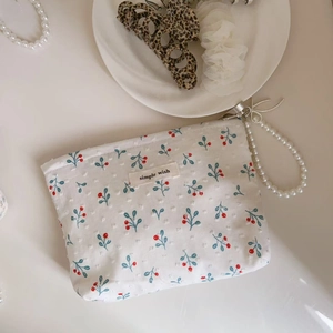 Close-up of blue floral cotton mini bag with pearl chain and simple wish label detail