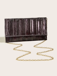 Detail of elegant pleated evening clutch in deep purple with golden chain strap