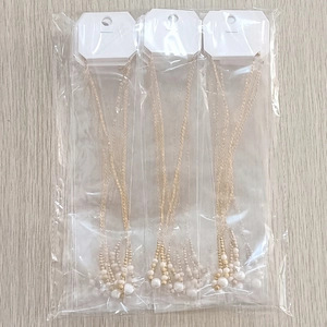 Detailed view of three-piece gold stainless steel necklace set with white pearls