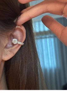 Detailed view of silver zircon ear cuff worn on ear bone with large clear crystal stone