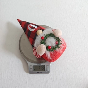 Ornamento di bambola gnomo di Natale con cappello a quadri rosso nero e ghirlanda.