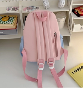 Detail view of pink student backpack showing wide shoulder straps and hidden back pocket