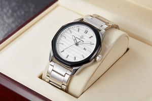Detail view of quartz watch with silver steel strap and black octagonal bezel in box