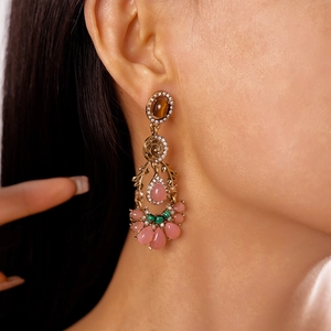 Close-up of vintage drop earring with amber and pink stones worn by a model