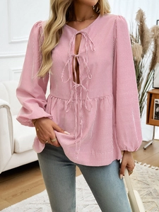 Detailed view of red and white striped V-neck top with lace-up front and ruffled hem