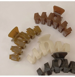 Flat lay of 13cm oversized acrylic shark hair claws in earth tone Morandi colors
