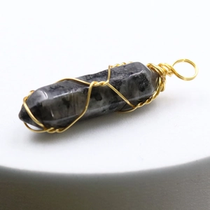 Detailed macro view of crystal hexagonal pendant wrapped in handcrafted gold wire