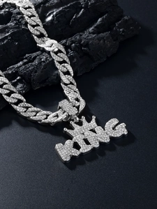 Macro shot of silver paved KING pendant with crown on thick Cuban link chain necklace