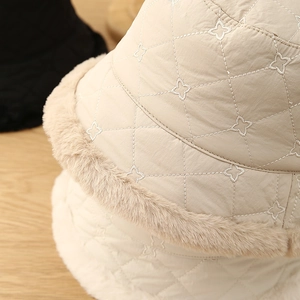 Close-up of beige winter bucket hat with star quilting and plush faux fur trim detail