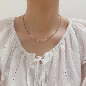 Detail of beaded choker with purple tourmaline, fresh water pearl and golden beads