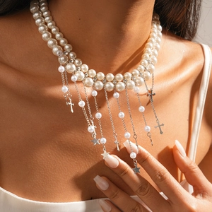 Collier élégant en perles baroques avec étoiles, croix et glands argentés sur modèle