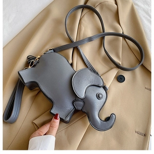 Close-up of grey elephant-shaped PU leather shoulder bag on a beige trench coat
