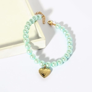 Close-up of light blue pearl pet collar with a gold heart pendant and I Love You engraving