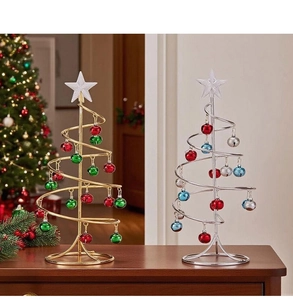 Detail of iron mini Christmas trees with colorful metal bells on a wooden table