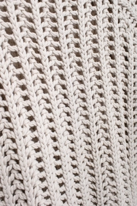 Vue détaillée de la maille épaisse d'un pull avec une texture tissée crème complexe