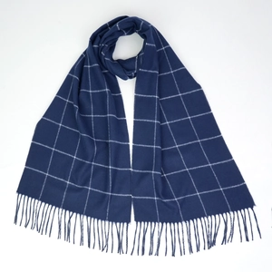 Detail of navy blue plaid scarf texture with soft fringe edges and white grid pattern