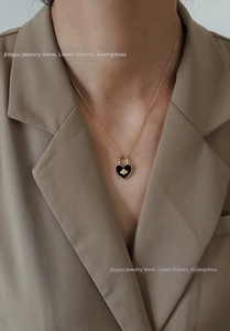 Close-up of a 18K gold plated heart lock pendant with a tiny bee on black enamel