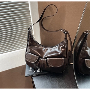 Detail of dark brown oil wax leather shoulder bag with two front pockets and vintage style