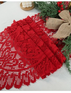 Close-up of red Christmas lace table runner with intricate floral patterns and tassels