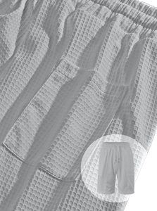 Detailed close-up of light grey waffle knit fabric shorts with adjustable drawstring waist