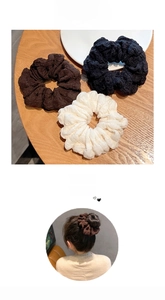 Detail of three textured oversized scrunchies in brown, black, and cream colors