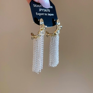 Detail of S925 silver fringe earrings with gold hammered texture and long chain tassels