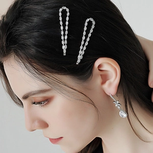 Close-up of elegant silver hair clips set with sparkling zircons on black hair