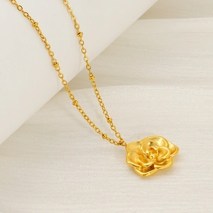 Macro d'un pendentif rose plaqué or 18 carats avec chaîne délicate sur texture blanche