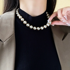 Close-up of champagne baroque pearl necklace with gold spacers on a model's neck
