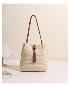 Detail of hand-woven cotton shoulder bag with wooden beads and brown tassel decoration