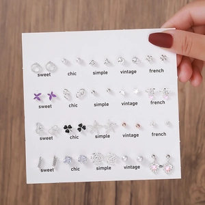 Gros plan d'un lot de 20 paires de boucles d'oreilles cœurs et perles sur présentoir