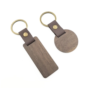 Detail view of rectangular and round wooden keychains with leather straps and metal rings