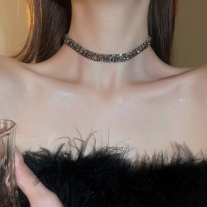 Close-up of French luxury necklace set featuring gunmetal base and dark grey zircons