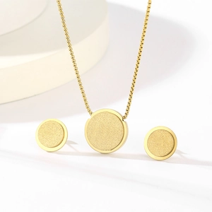 Detail of minimalist gold-plated star jewelry set with matte textured round pendants