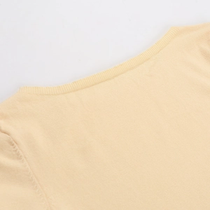 Detalle del cuello redondo y tejido de punto en vestido línea A color crema